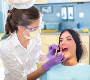 woman being examined by a dental hygienist