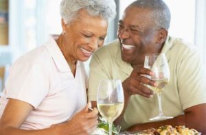 older couple laughing and drinking wine